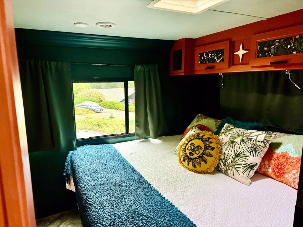Class A motorhome bedroom with dark green walls